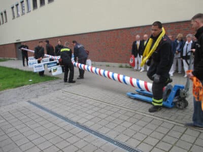 Der Maibaum wird durch Feuerwehrleute für den Transport vorbereitet.
